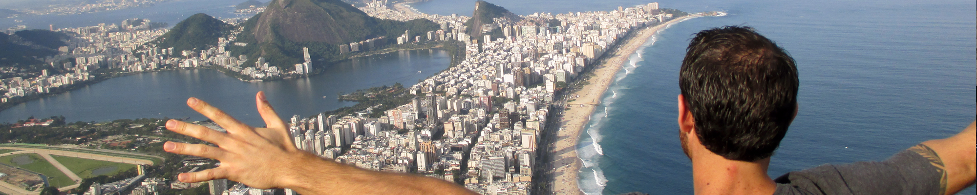student in Brazil, on mountain with arms open wide